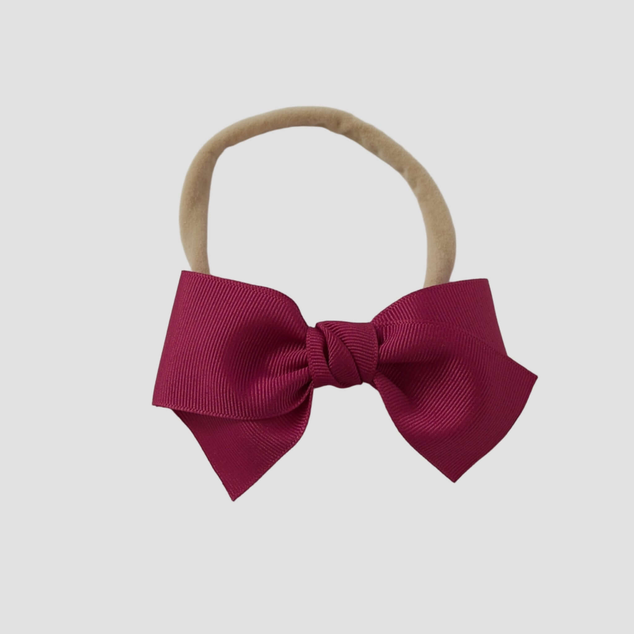 Azalea grosgrain Kayla hair bow on a nude nylon headband against a white background