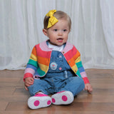 Adorable toddler wearing a rainbow cardigan and denim overalls, complete with a bright yellow Kayla hair clip bow for a stylish look.