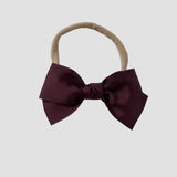 Maroon grosgrain Kayla bow on a nude nylon headband against a white background