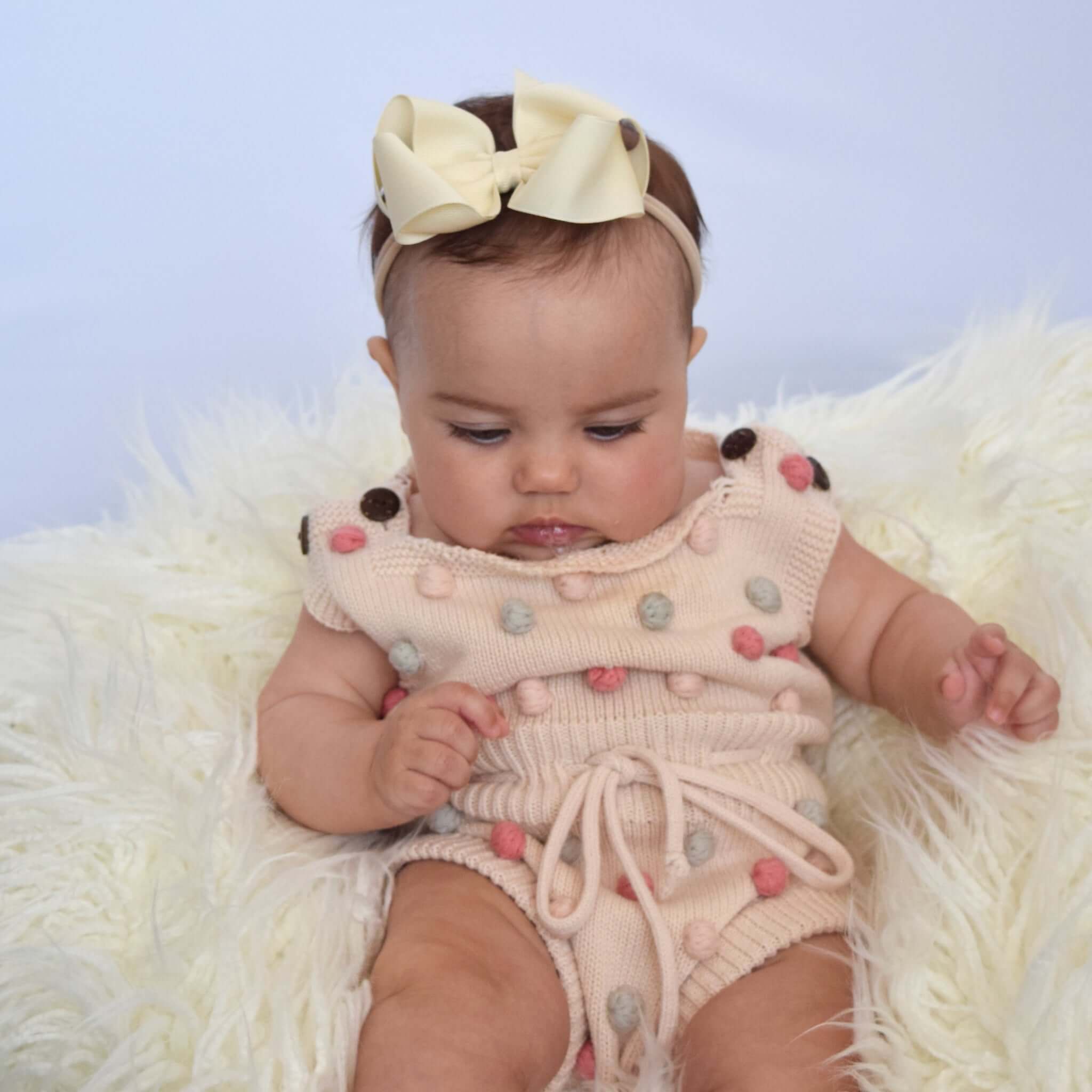 Baby wearing sustainable recycled polyester matte satin bow headband