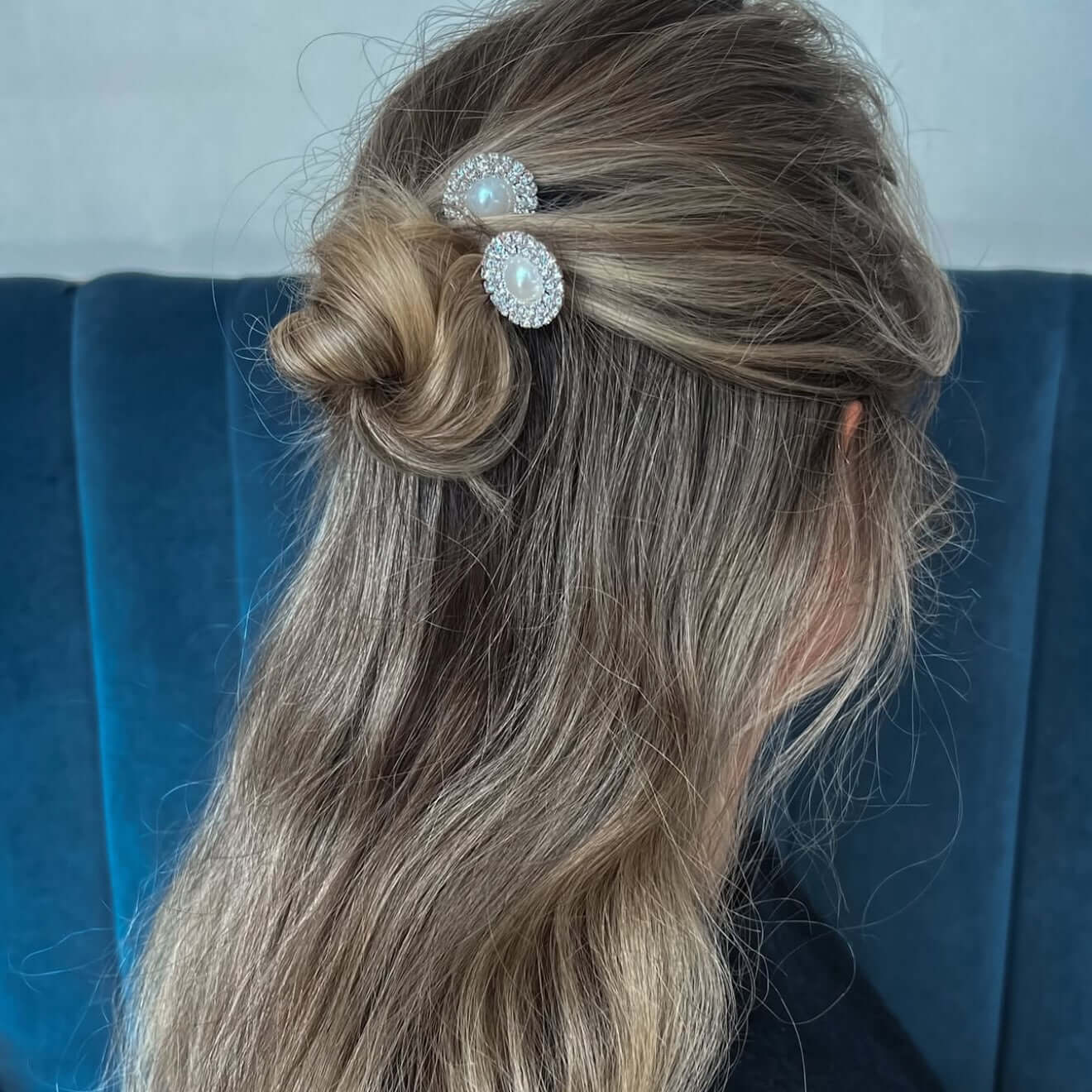 Women wearing half up bun with two pearl and rhinestone hair pins