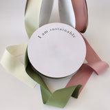 Eco-friendly recycled ribbon packaging with pastel colors and 'I am sustainable' message.