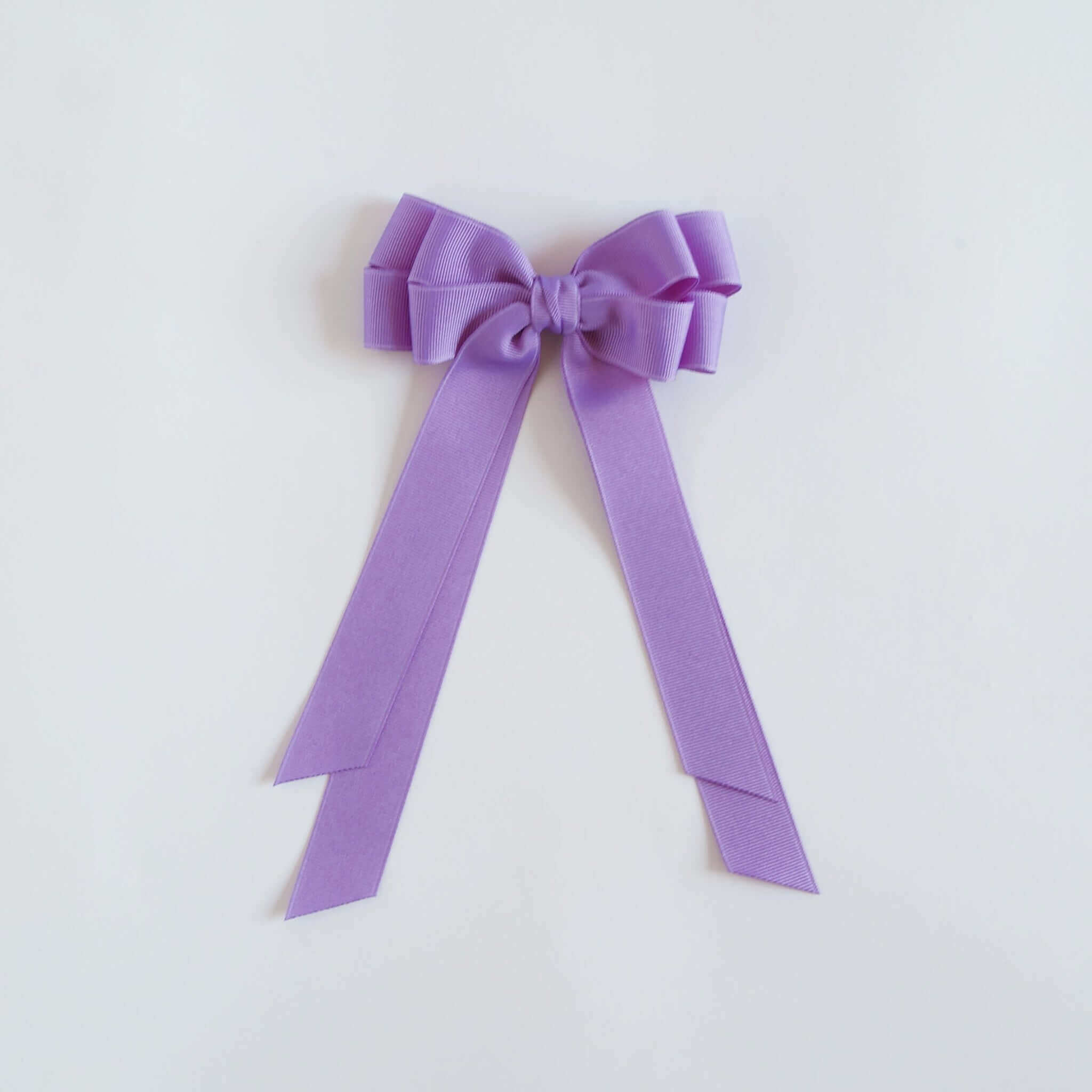 Dark orchid purple bow on a white background