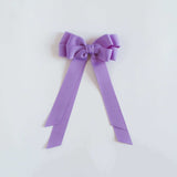 Dark orchid purple bow on a white background