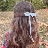 Olivia Matte Satin Bow in white, handcrafted with sustainable recycled ribbon, worn in little girls long hair for a stylish look.