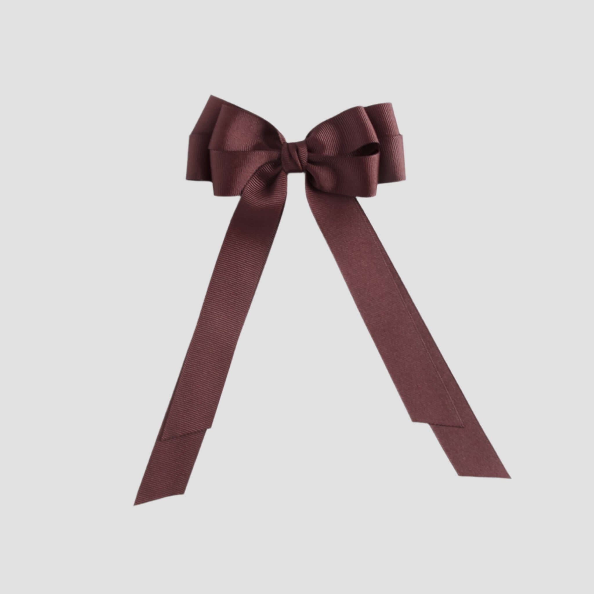 Maroon bow with long tails on a white background