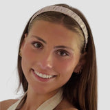 Woman wearing 1 inch Hannah headband in taupe against a plain background
