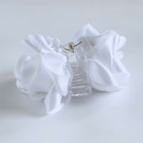 Side view of white satin flower claw clip with clear base and gold hinge