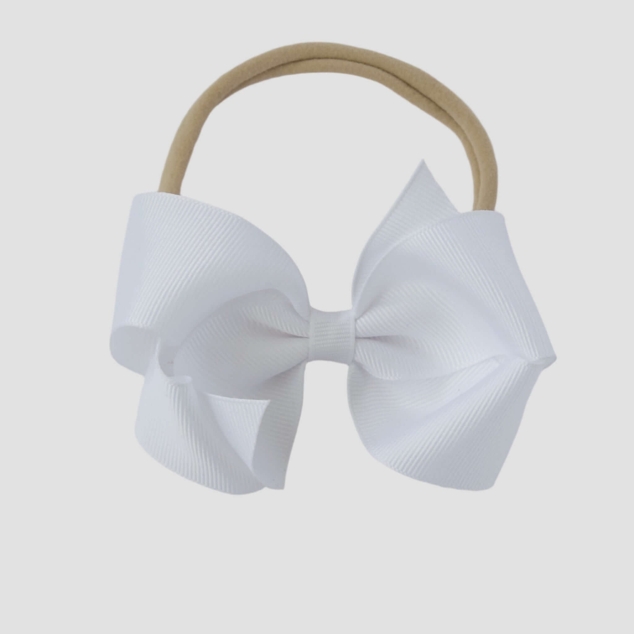 White bow on a nude nylon headband against a white background