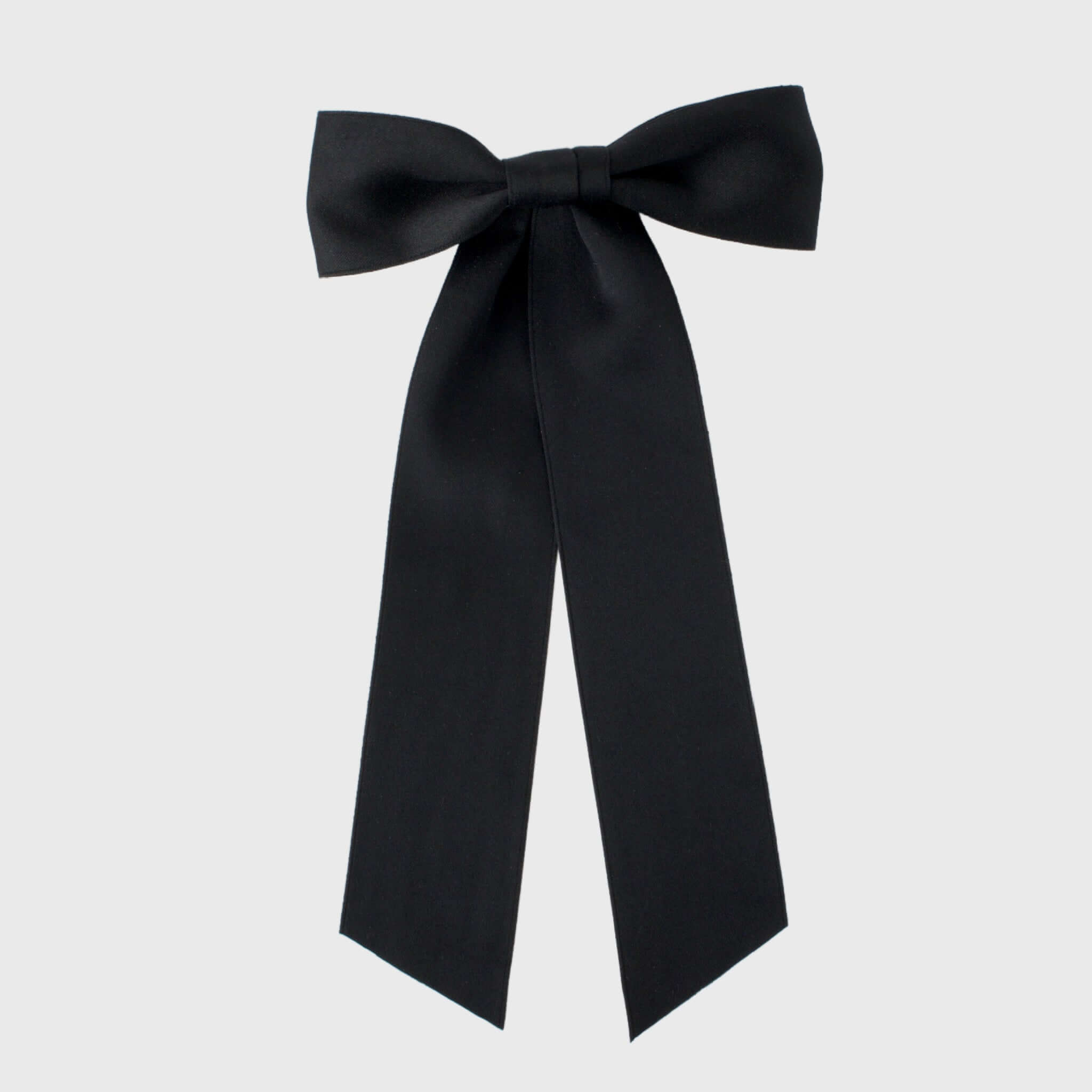 Oversized long tail black satin hair bow handmade with sustainable recycled matte satin ribbon for weddings and everyday wear.