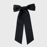 Oversized long tail black satin hair bow handmade with sustainable recycled matte satin ribbon for weddings and everyday wear.