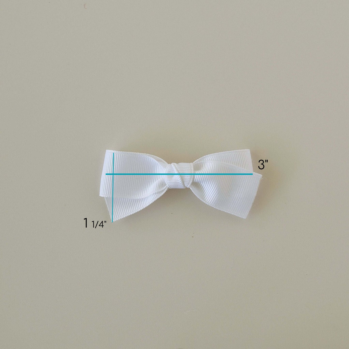 White 3 inch Grosgrain Baby Kayla Bow with alligator clip measuring guide on light background.