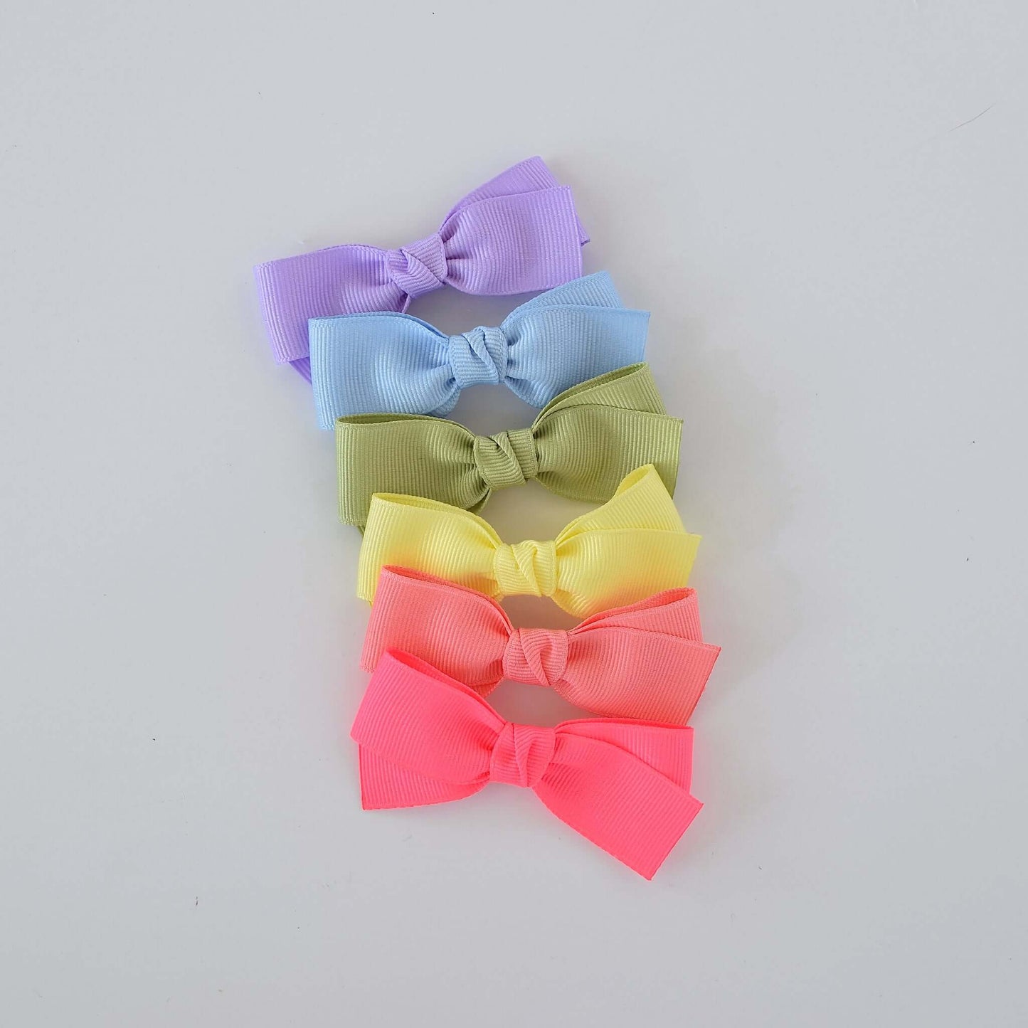 Assorted pastel Kayla bow clips in lavender, blue, green, yellow, and coral grosgrain ribbon.