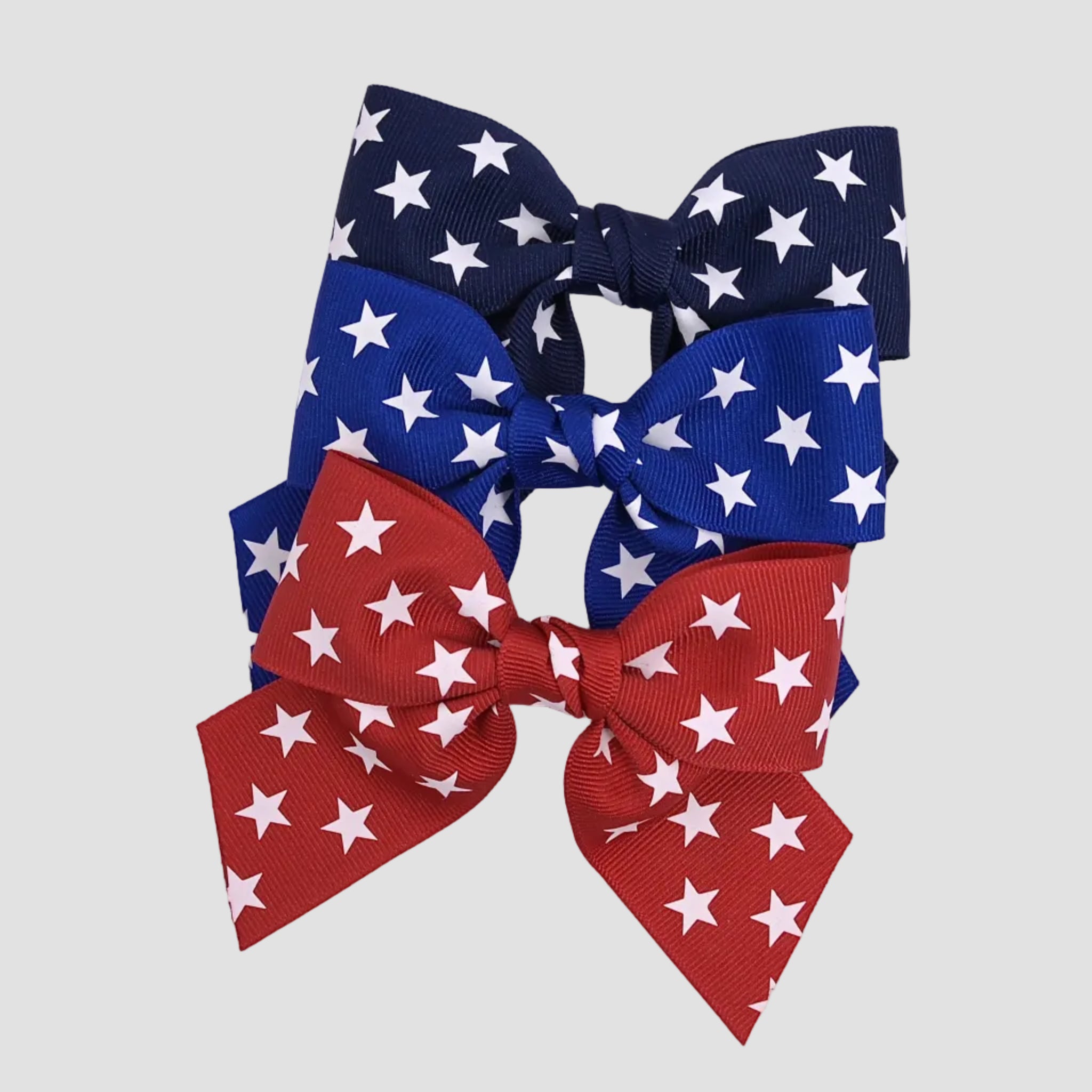 4 inch sailor hair bow with stars in navy, red and royal blue on a white background.