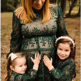 Woman and two young girls in matching green lace outfits outdoors. One girl is wearing velvet Kayla in ivory