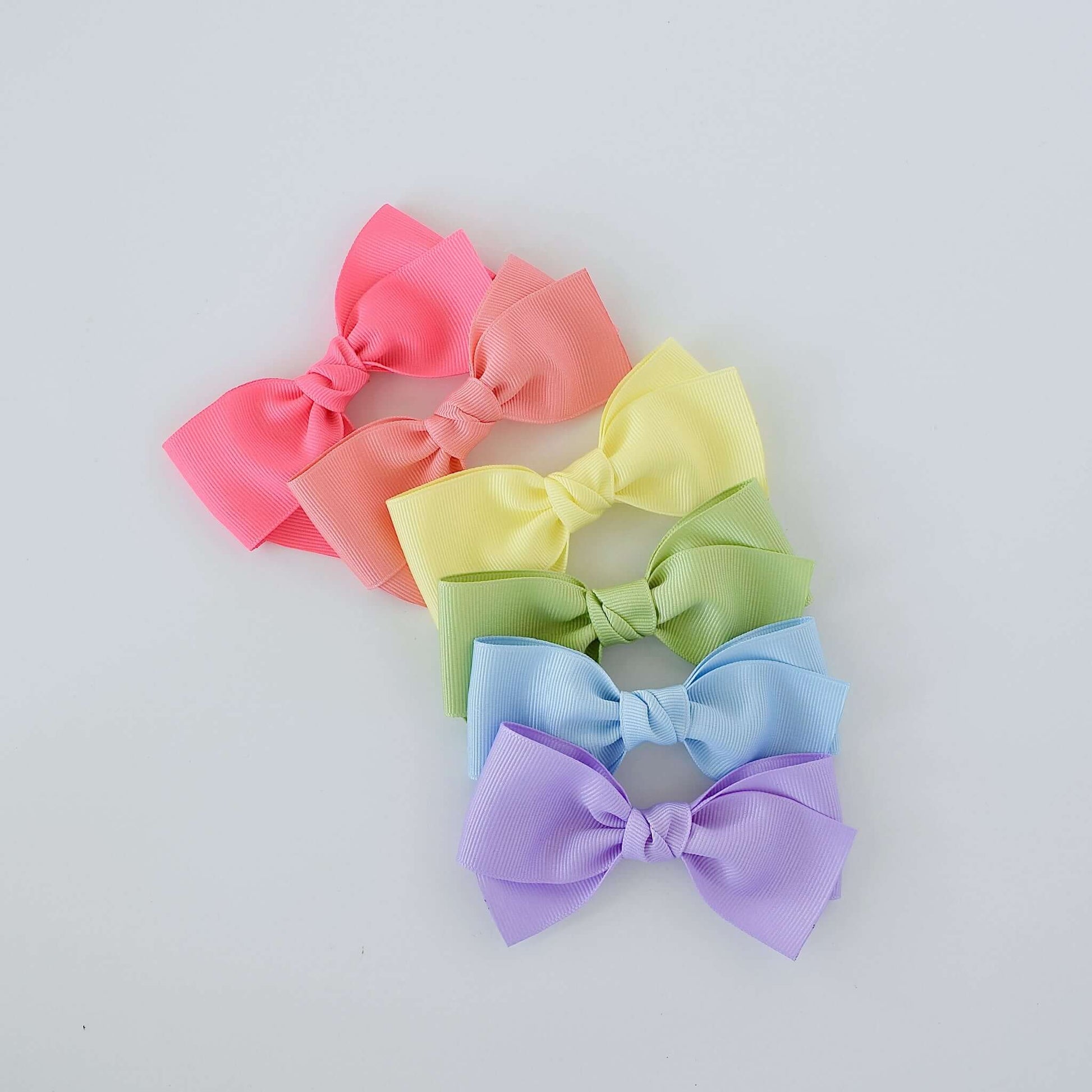 4 inch grosgrain baby Kayla bow clips in pastel colors including pink, peach, yellow, green, blue, and purple, perfect for toddlers and newborns.