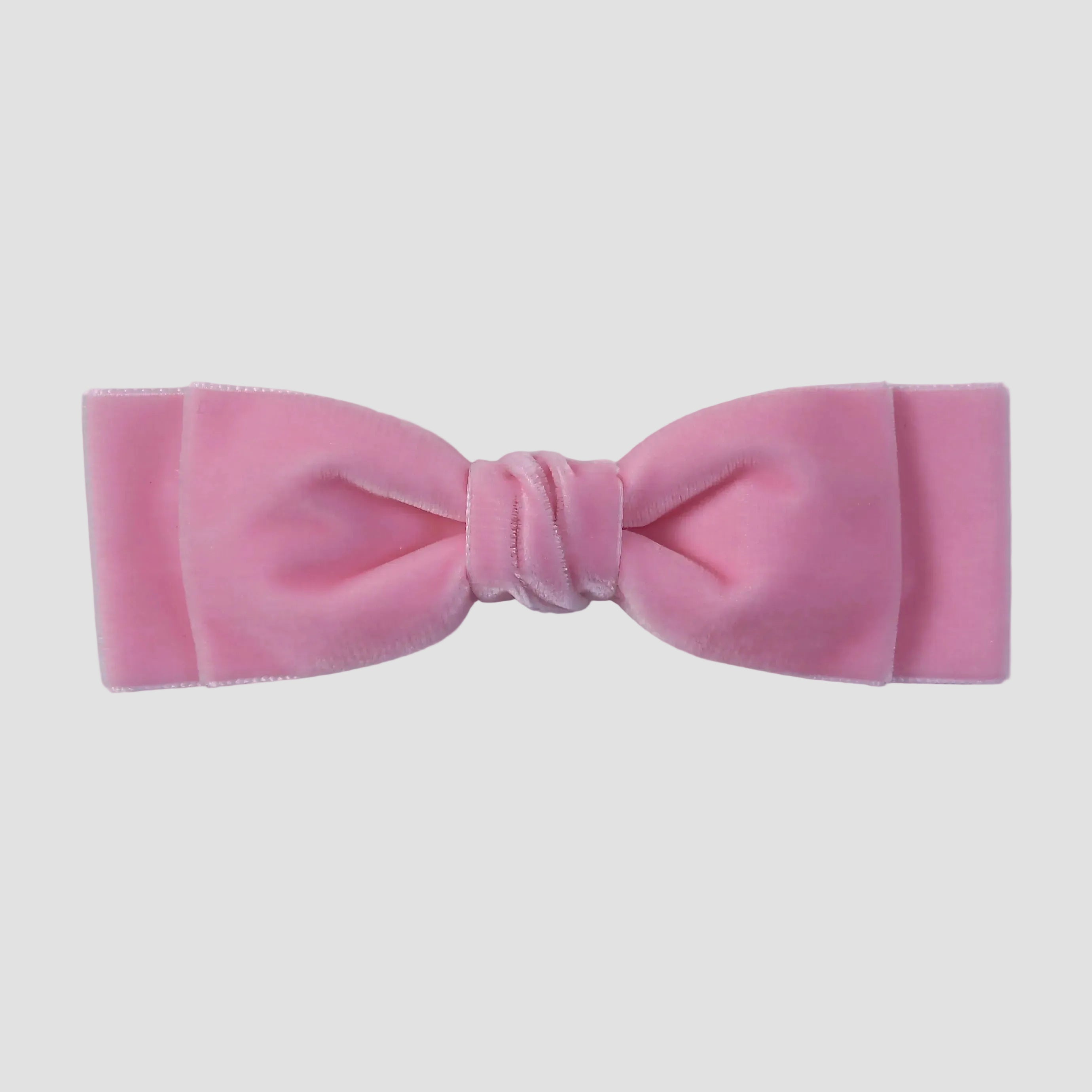 Blush pink velvet hair bow on a white background