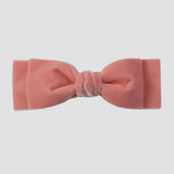 Coral velvet hair bow on a white background