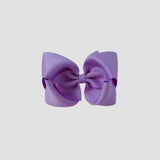 Dark orchid purple hair bow on a white background