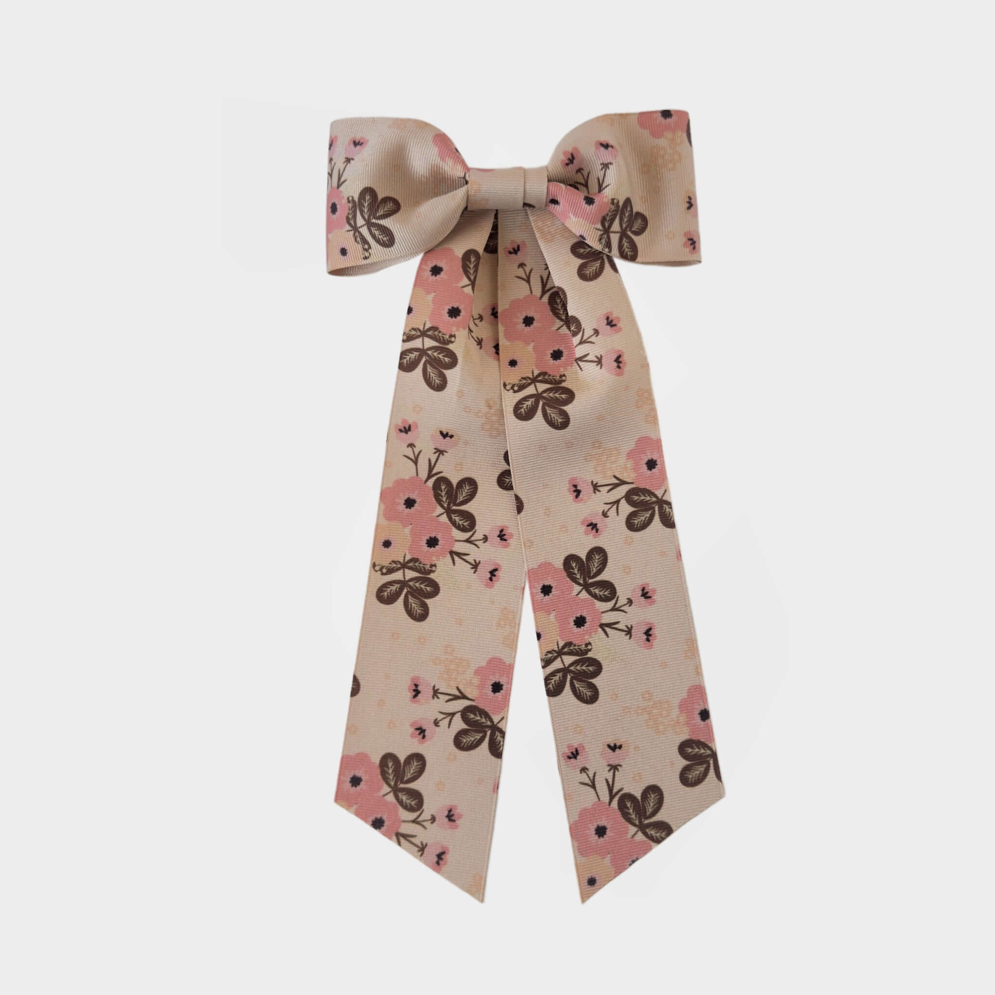 A beige bow ribbon adorned with pink flowers and brown leaves on a white background. The bow has a playful and elegant touch, conveying a cheerful mood.