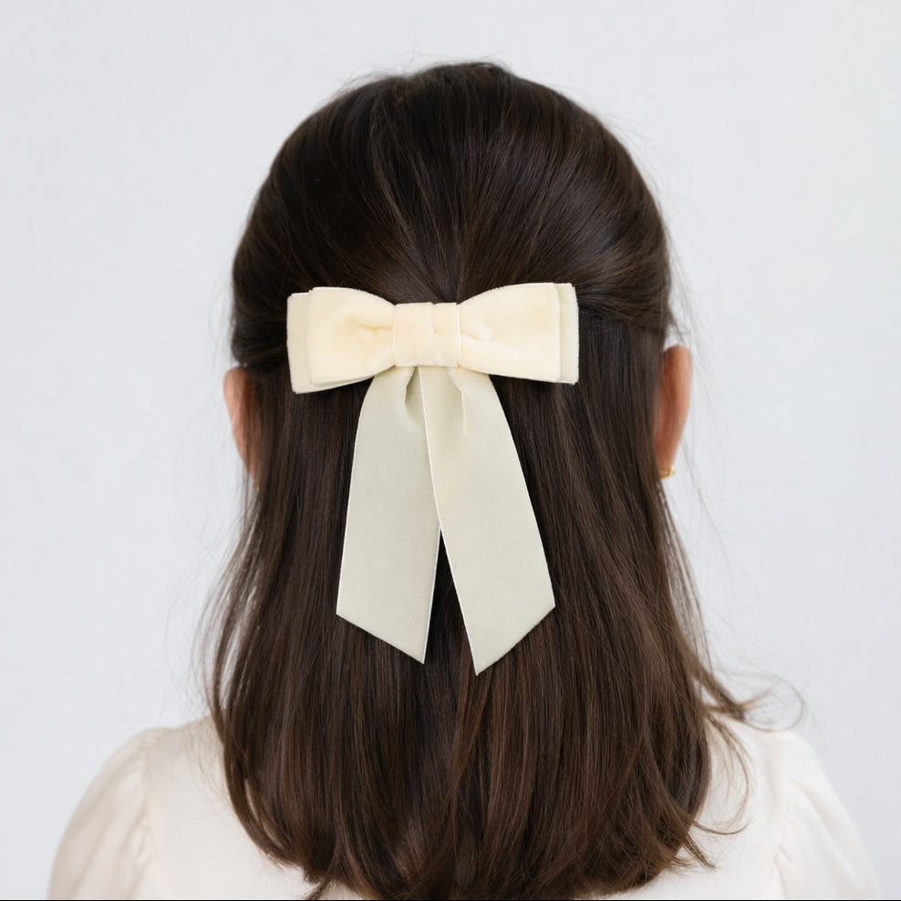 Young girl wearing Mia velvet hair bow in ivory