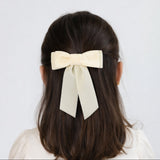 Young girl wearing Mia velvet hair bow in ivory