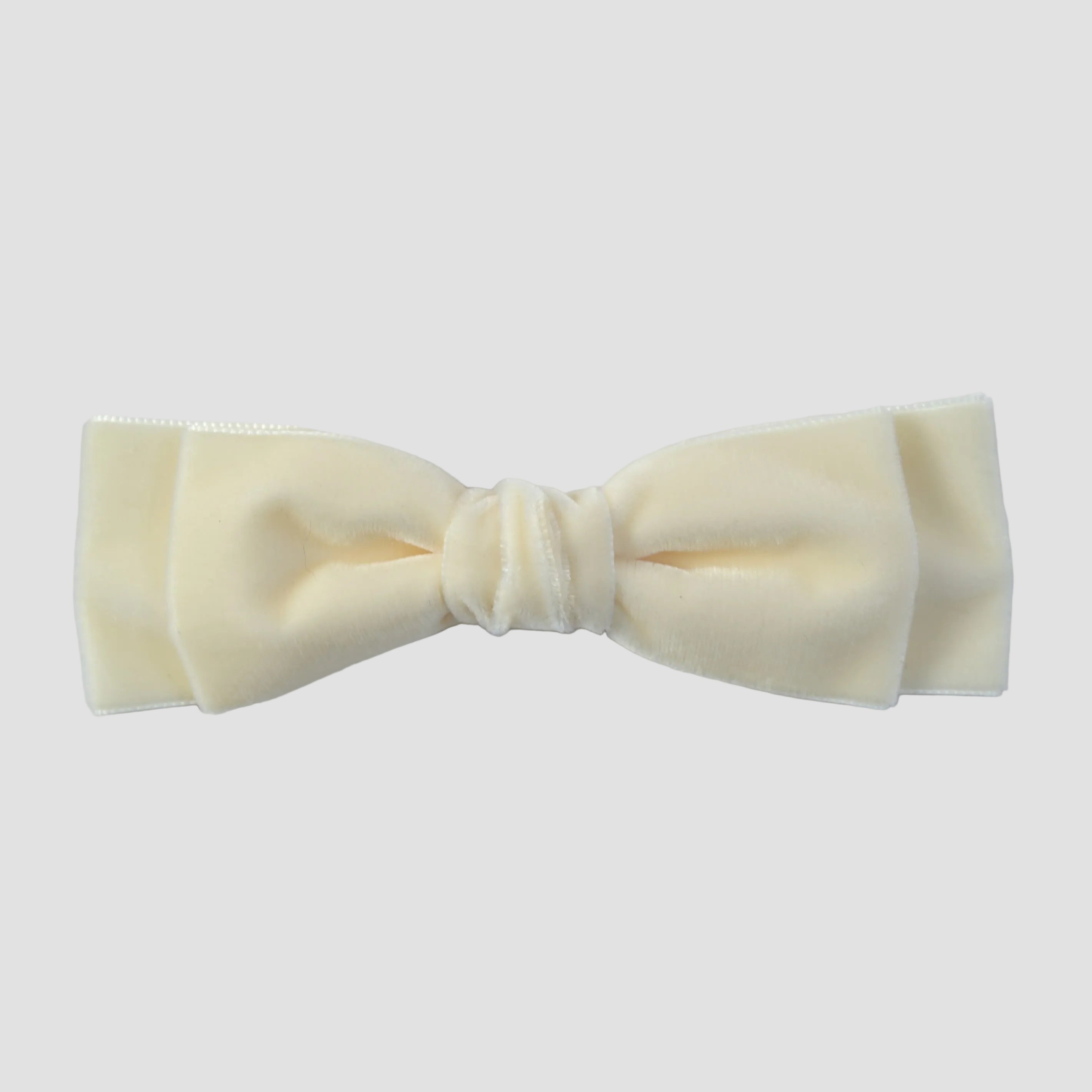 Ivory velvet hair bow on a white background