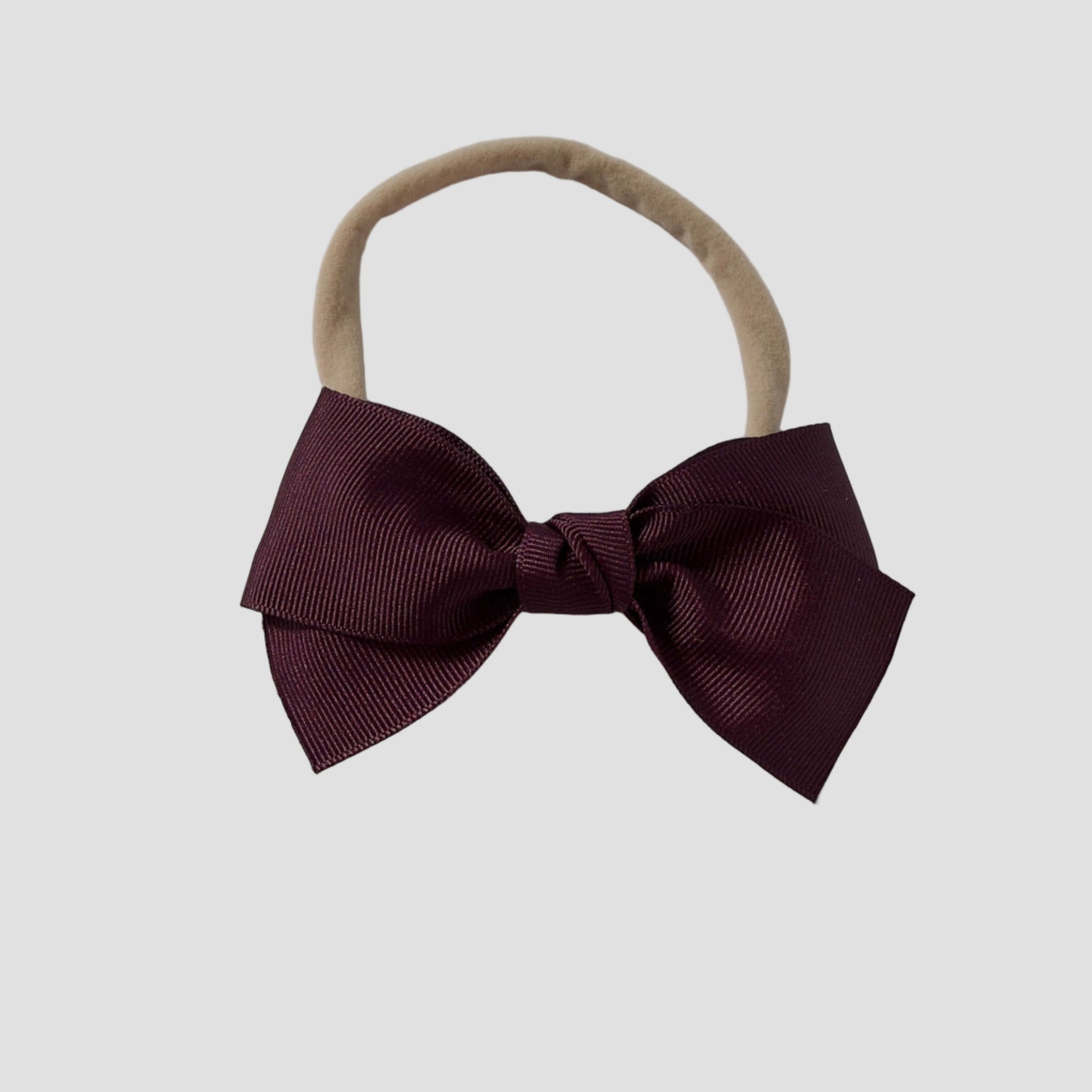 Maroon grosgrain Kayla bow on a nude nylon headband against a white background