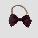 Maroon grosgrain Kayla bow on a nude nylon headband against a white background