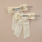 Backside of the Mia velvet hair bows showing barrettes and alligator clips choices on a beige background.
