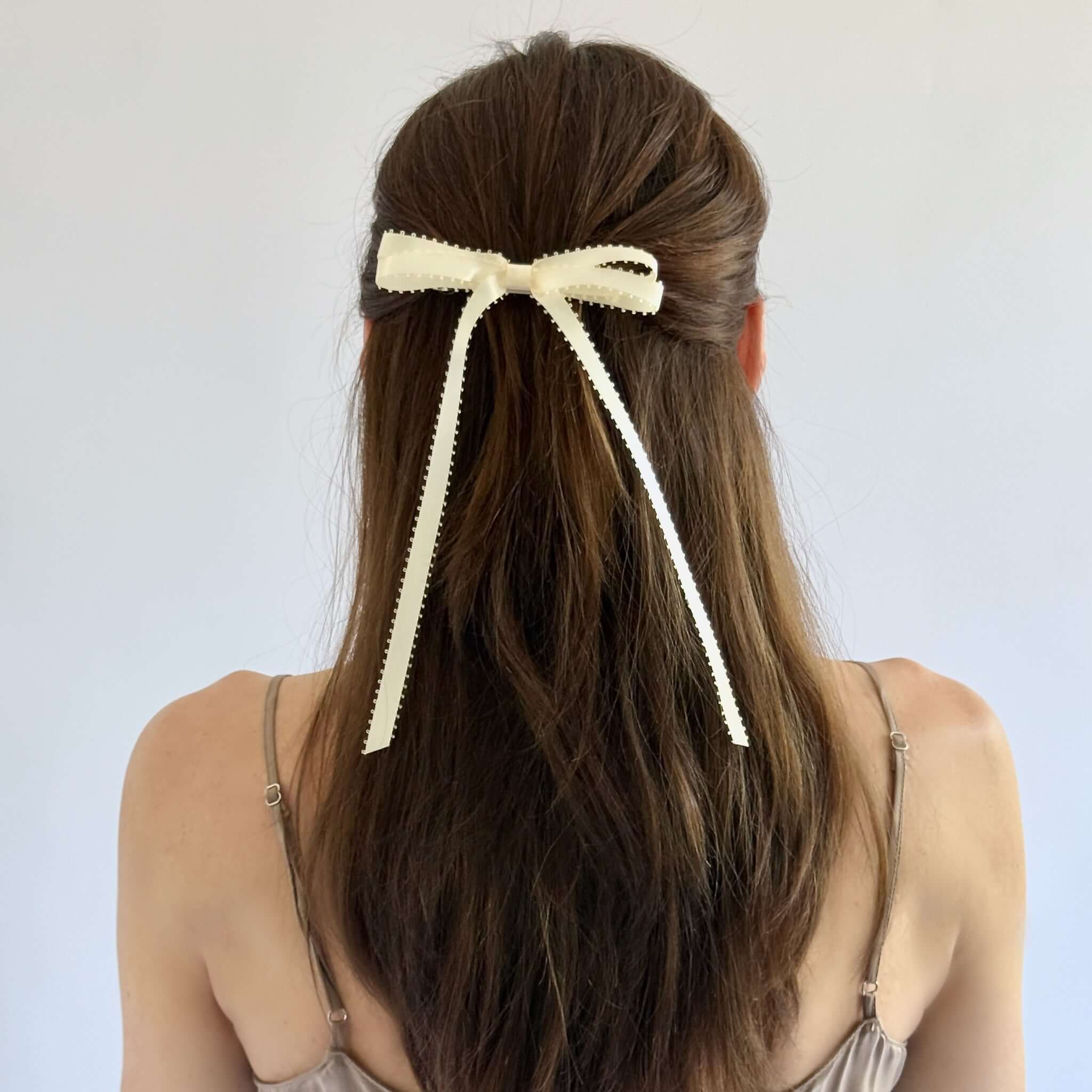 Olivia Picot Satin Bow accessory on a woman's hairstyle, featuring delicate picot edges and smooth satin ribbon.