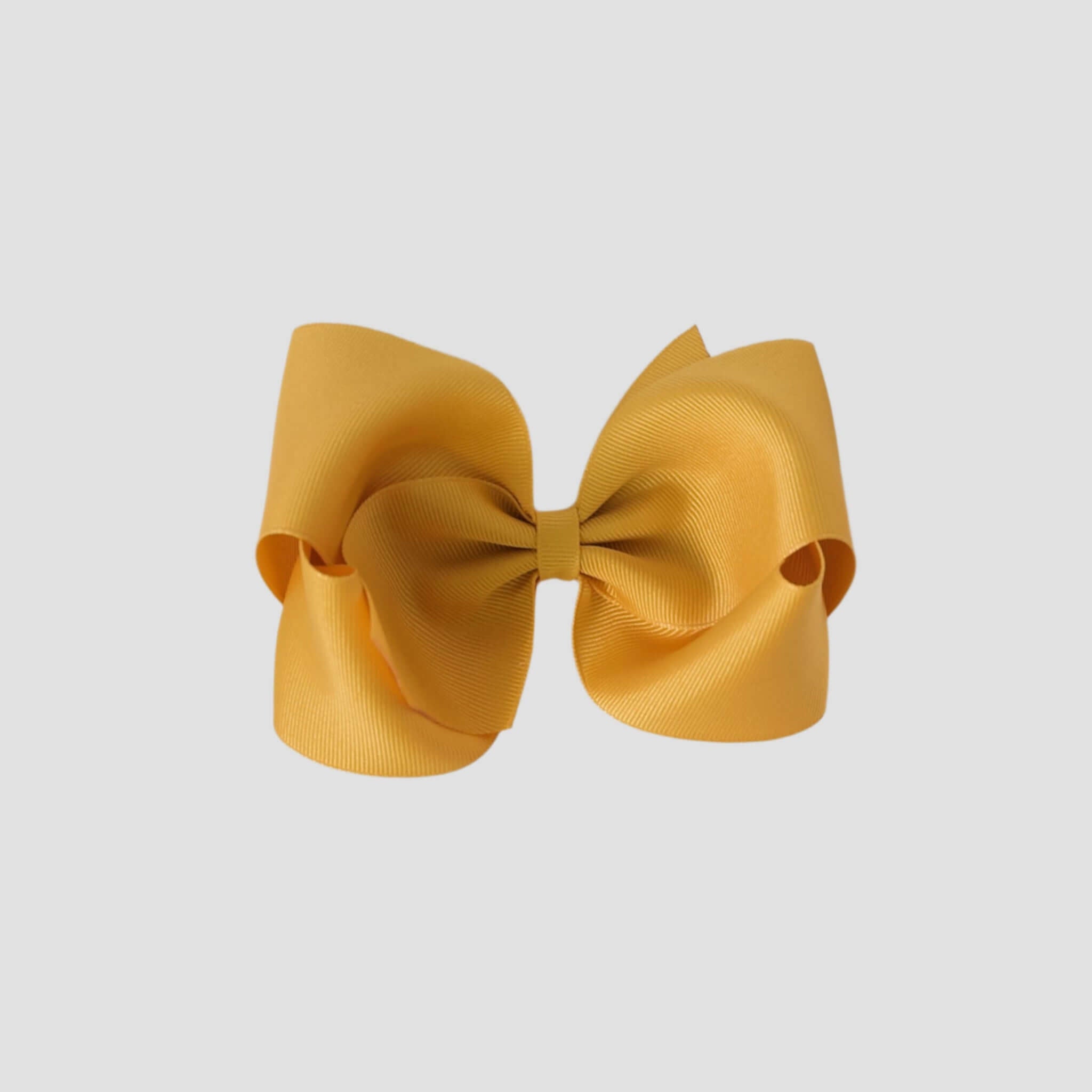 Mustard yellow hair bow on a white background