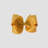 Mustard yellow hair bow on a white background