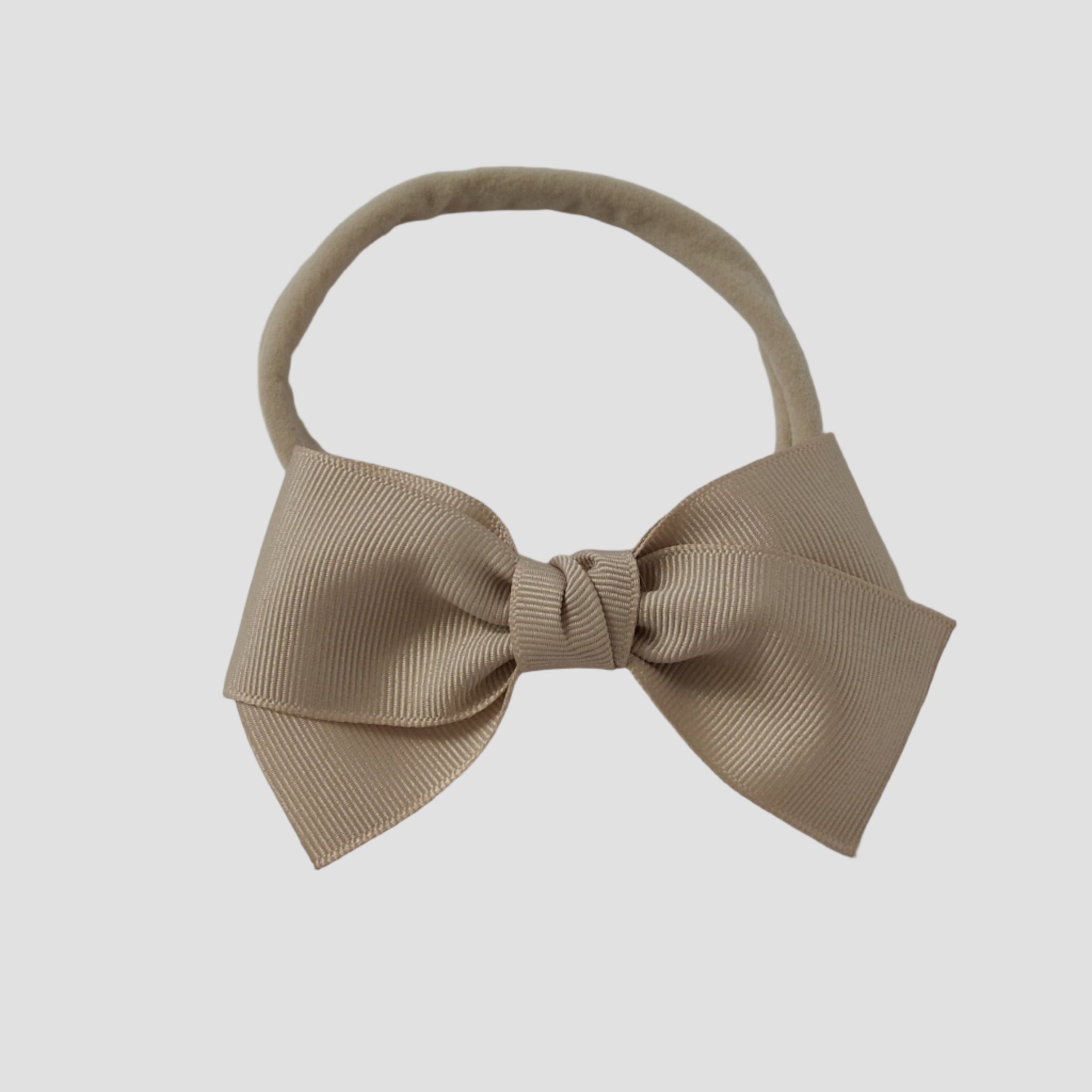 Oatmeal beige grosgrain Kayla hair bow on a nude nylon headband against a white background