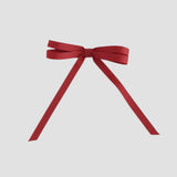 Cranberry red ribbon bow on a white background