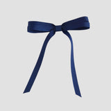 Light navy blue ribbon bow on a white background