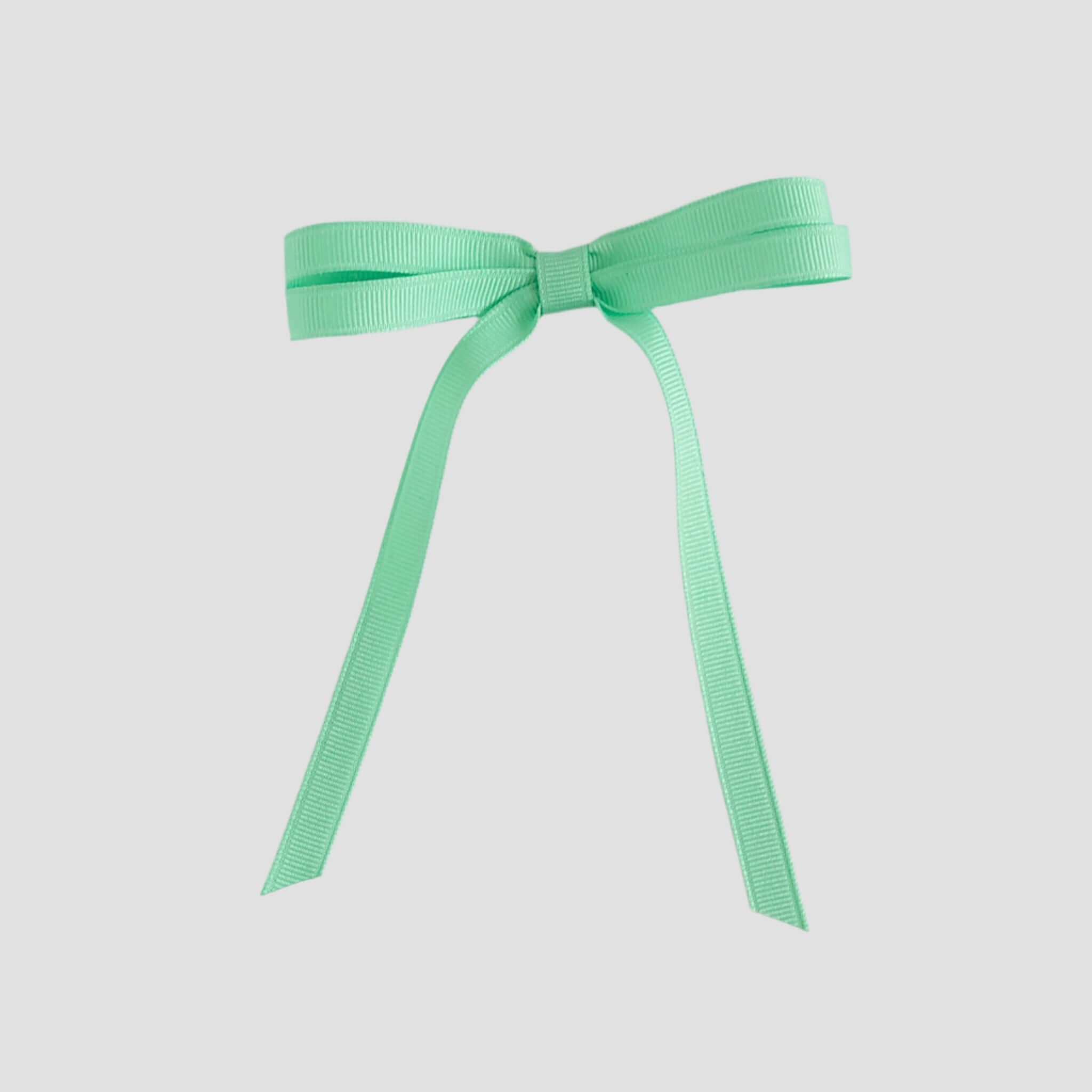 Mint green ribbon bow on a white background
