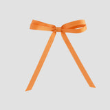 Pumpkin orange grosgrain ribbon bow on a white background