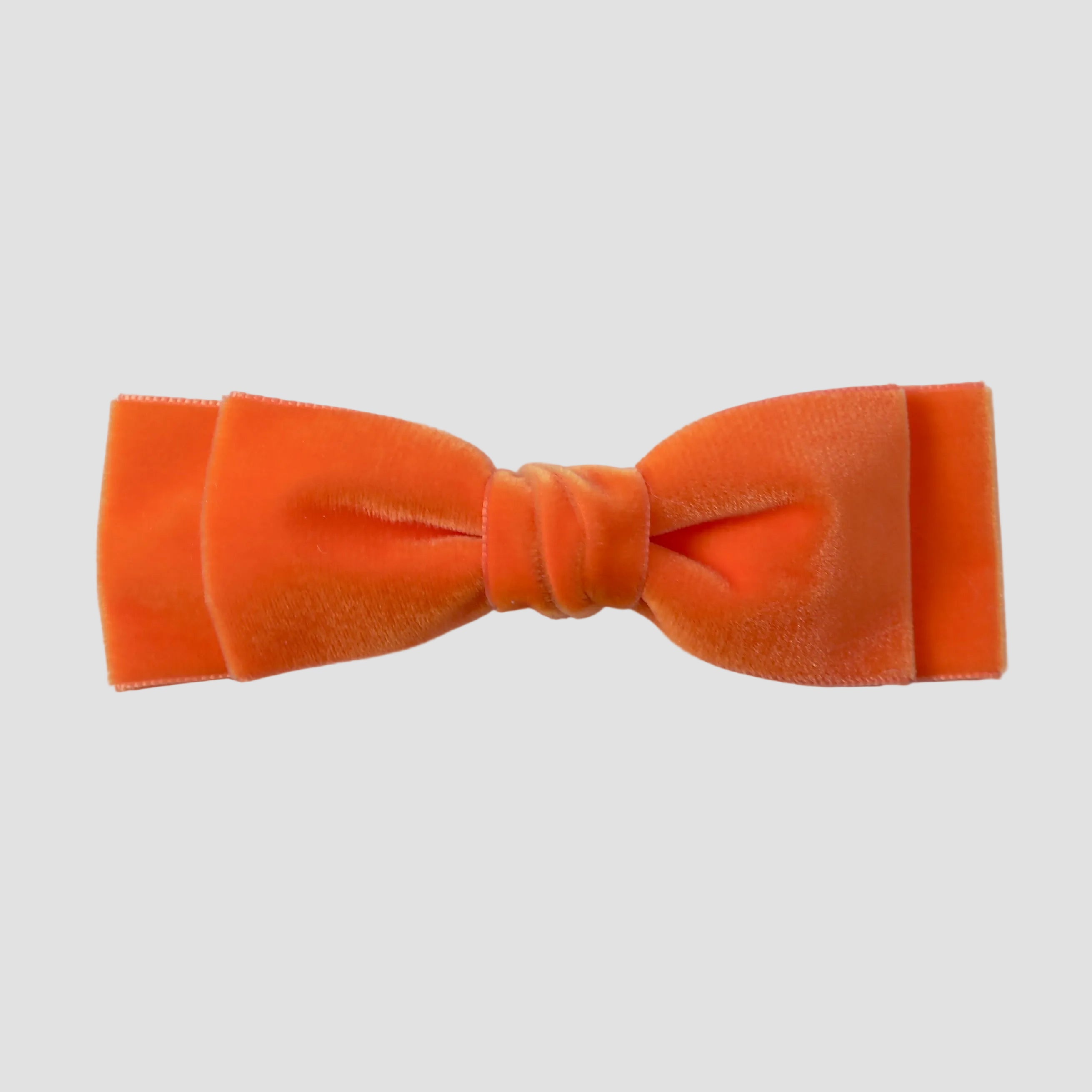 Orange velvet hair bow tie on a white background