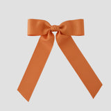 Pumpkin orange grosgrain Zoe Petite bow on a white background
