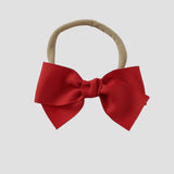 Red grosgrain bow on a ude nylon headband