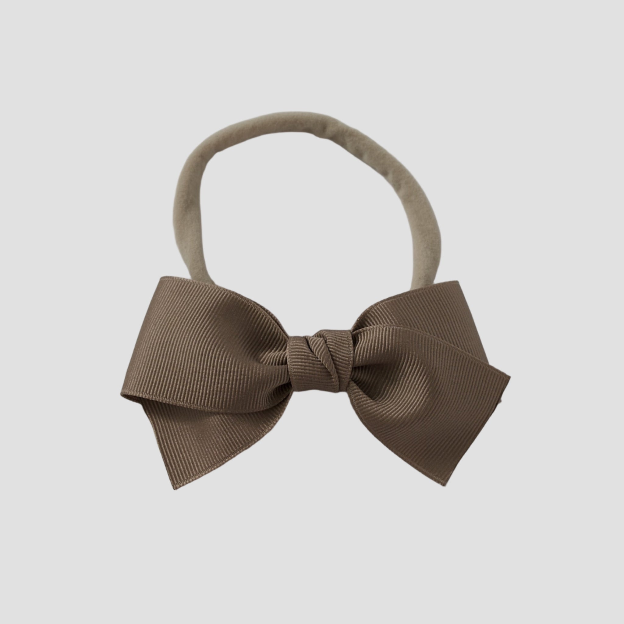 Taupe grosgrain Kayla hair bow on a nude nylon headband against a white background