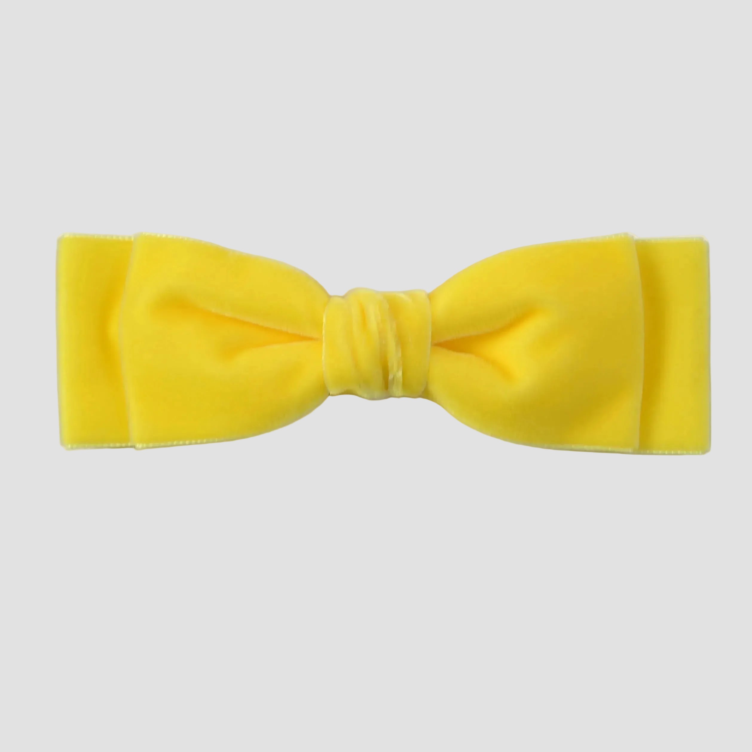 Yellow velvet hair bow on a white background