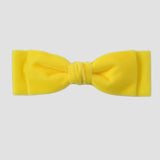 Yellow velvet hair bow on a white background