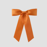 Tangerine orange Zoe petite satin hair bow on a white background