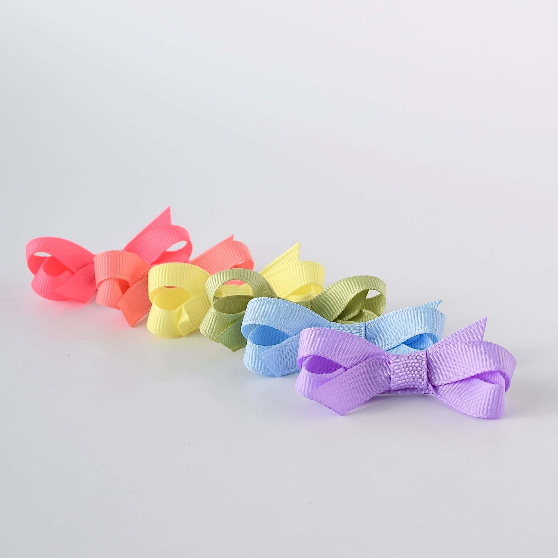 Mini grosgrain bows for baby and toddler girls, set of 6 in bright pastel colors, handmade in the USA with no-slip snap clips.