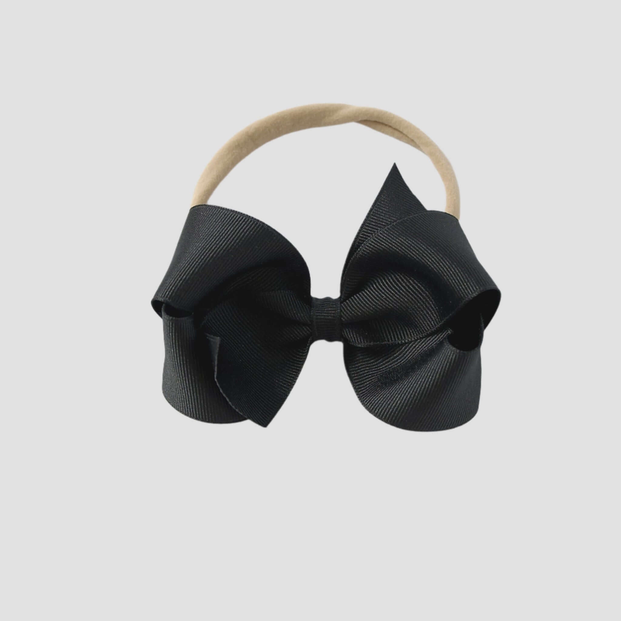 Black bow on a nude nylon headband 