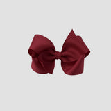 Cranberry red hair bow on a white background