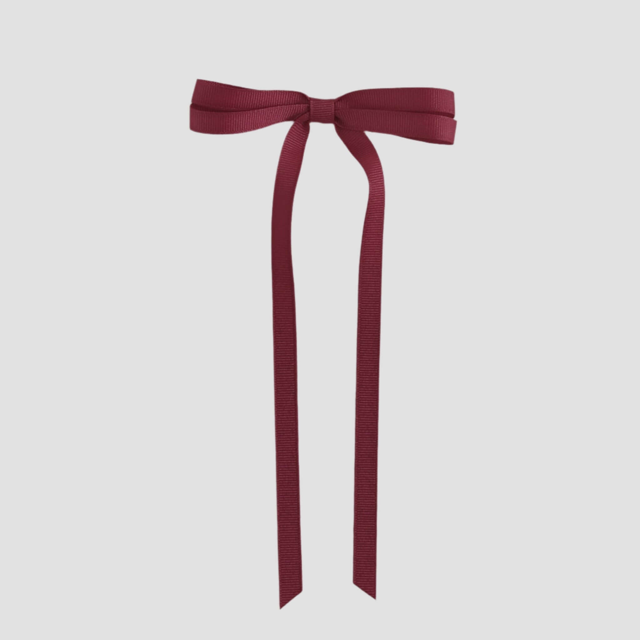 Cranberry red ribbon bow on a white background