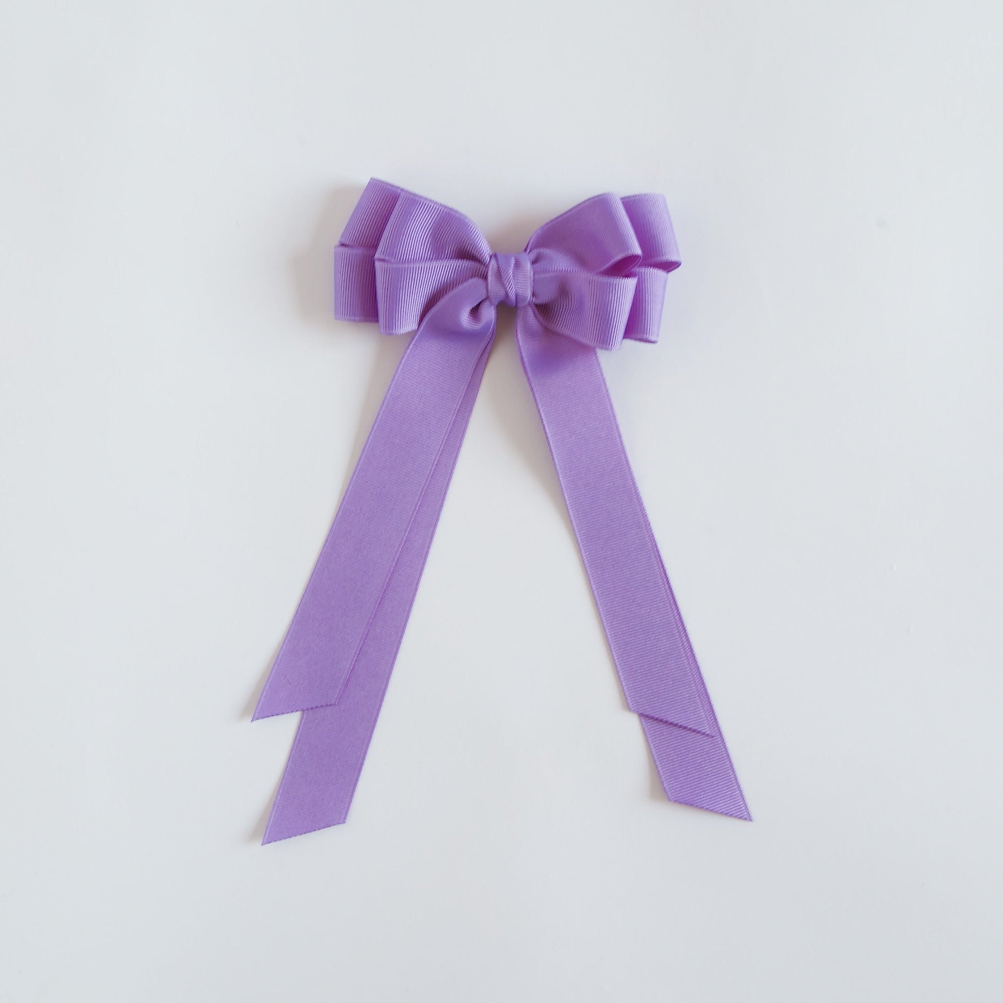 Dark orchid purple bow on a white background